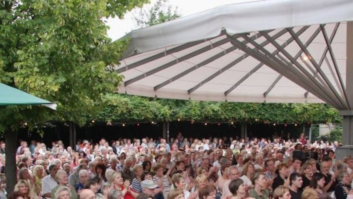 Veranstaltung auf dem Kulturparkplatz unter dem großem Schirm hinter dem Rathaus